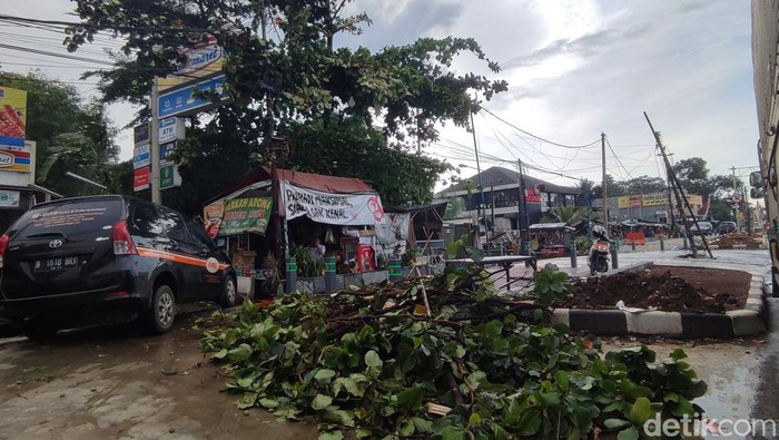 Hujan disertai angin kencang terjadi di Kabupaten Bogor hingga dahan-dahan pohon di sekitar tumbang mengenai salah satu mobil dan kabel listrik. Begini kondisi terkini di lokasi (Rizky AM/detikcom)