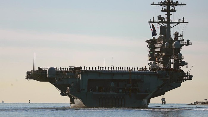 Sailors and marines line the deck of aircraft carrier USS Abraham Lincoln (CVN-72) as it deploys from San Diego on Monday, Jan. 3, 2021. The USS Abraham Lincoln deployed Monday from Naval Air Station North Island as part of the Abraham Lincoln Carrier Strike Group, under the command of Capt. Amy Bauernschmidt, the first woman to lead a nuclear carrier in U.S. Navy history. (K.C. Alfred/The San Diego Union-Tribune via AP)