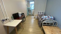 Kamar di kamp karantina wajib Hong Kong dilengkapi dua tempat tidur single dengan kasur tipis, bantal spons keras dan selimut, dua meja kecil dengan televisi kecil, ketel listrik, pengering rambut, dua kursi lipat plastik, lemari kain, meja samping tempat tidur, AC, dan pemanas air.
