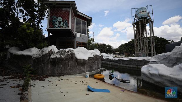 Pekerja melakukan perancangan proyek revitalisasi Taman Mini Indonesia Indah (TMII), Senin (24/1/2022). Snowbay Waterpark dulunya dikenal sebagai wahana favorit anak-anak, sayangnya karena COVID-19, kolam renang dengan berbagai wahana itu harus ditutup selama nyaris 2 tahun. Beberapa kondisi fisik yang terbengkalai terlihat dilokasi ini mulai pintu masuk tiket dan rak tempat penitipan barang. Kondisi Snowbay Waterpark saat ini memang tak terurus karena sudah lama tutup. Sejumlah kolam renang dibiarkan begitu saja hingga airnya keruh. Terlihat juga toko-toko yang dulu menjual perlengkapan renang dan kuliner juga tutup.  
Dikutip dari situs tamanmini.com, Snowbay Waterpark mulanya dirancang secara khusus sebagai taman rekreasi petualangan berkelas dunia berkonsep pegunungan salju
Taman seluas 3 hektar ini dibangun tahun 2008 dan diresmikan pembukaannya oleh ketua Yayasan harapan Kita, Hj. Siti Hardiyanti Rukmana pada tanggal 19 April 2009. Sebelumnya, taman ini adalah Taman Rekreasi Ambar Tirta. (CNBC Indonesia/ Tri Susilo)