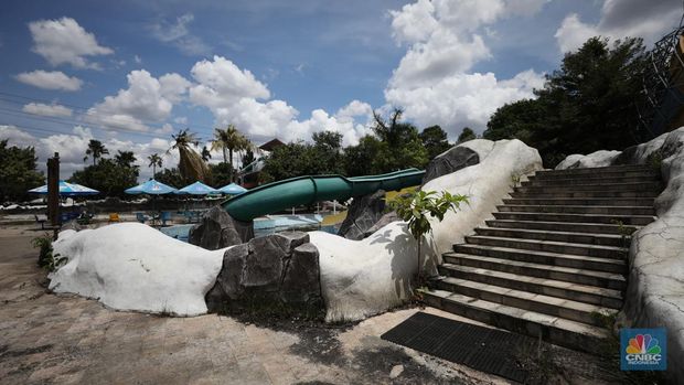 Pekerja melakukan perancangan proyek revitalisasi Taman Mini Indonesia Indah (TMII), Senin (24/1/2022). Snowbay Waterpark dulunya dikenal sebagai wahana favorit anak-anak, sayangnya karena COVID-19, kolam renang dengan berbagai wahana itu harus ditutup selama nyaris 2 tahun. Beberapa kondisi fisik yang terbengkalai terlihat dilokasi ini mulai pintu masuk tiket dan rak tempat penitipan barang. Kondisi Snowbay Waterpark saat ini memang tak terurus karena sudah lama tutup. Sejumlah kolam renang dibiarkan begitu saja hingga airnya keruh. Terlihat juga toko-toko yang dulu menjual perlengkapan renang dan kuliner juga tutup.  Dikutip dari situs tamanmini.com, Snowbay Waterpark mulanya dirancang secara khusus sebagai taman rekreasi petualangan berkelas dunia berkonsep pegunungan saljuTaman seluas 3 hektar ini dibangun tahun 2008 dan diresmikan pembukaannya oleh ketua Yayasan harapan Kita, Hj. Siti Hardiyanti Rukmana pada tanggal 19 April 2009. Sebelumnya, taman ini adalah Taman Rekreasi Ambar Tirta. (CNBC Indonesia/ Tri Susilo)