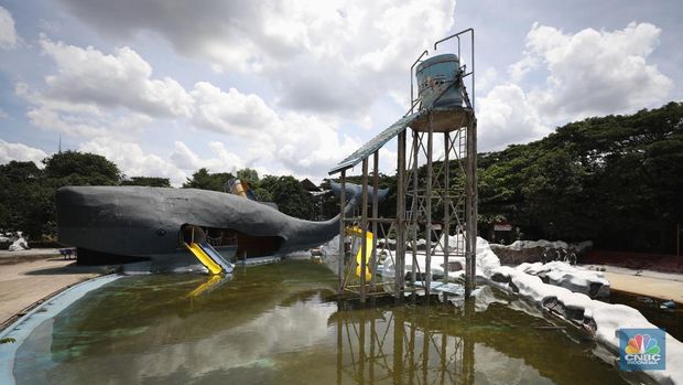 Pekerja melakukan perancangan proyek revitalisasi Taman Mini Indonesia Indah (TMII), Hari Senin (24/1/2022). Snowbay Waterpark dulunya dikenal sebagai wahana favorit anak-anak, sayangnya lantaran COVID-19, kolam renang dengan berbagai wahana itu harus ditutup selama nyaris 2 tahun. Beberapa kondisi fisik yang mana terbengkalai terlihat dilokasi ini mulai pintu masuk tiket kemudian rak tempat penitipan barang. Kondisi Snowbay Waterpark ketika ini memang sebenarnya tak terurus akibat telah lama tutup. Sejumlah kolam renang dibiarkan begitu semata hingga airnya keruh. Terlihat juga toko-toko yang digunakan dulu berjualan perlengkapan renang dan juga kuliner juga tutup.  Dikutip dari situs tamanmini.com, Snowbay Waterpark mulanya dirancang secara khusus sebagai taman rekreasi petualangan berkelas dunia berkonsep pegunungan saljuTaman seluas 3 hektar ini dibangun tahun 2008 juga diresmikan pembukaannya oleh ketua Yayasan harapan Kita, Hj. Siti Hardiyanti Rukmana pada tanggal 19 April 2009. Sebelumnya, taman ini adalah Taman Rekreasi Ambar Tirta. (CNBC Indonesia/ Tri Susilo)