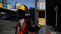 Tampak petugas menekan tombol untuk menyalakan lampu agar warga bisa menyeberang.