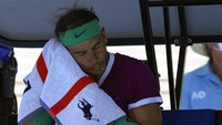 Rafael Nadal dari Spanyol menyeka keringat di wajahnya saat istirahat dalam pertandingan putaran keempat melawan Adrian Mannarino dari Prancis pada kejuaraan tenis Australia Terbuka di Melbourne, Australia, Minggu, (23/1/2022). (AP Photo/Simon Baker)