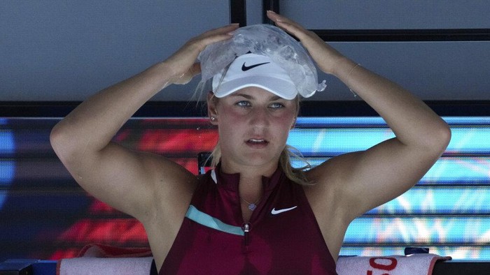 Panas Dingin Australian Open 2022, Ini Cara Petenis Agar Tetap Rileks Marta Kostyuk of Ukraine places a bag of ice on her head during her third round match against Paula Badosa of Spain at the Australian Open tennis championships in Melbourne, Australia, Friday, Jan. 21, 2022. (AP Photo/Simon Baker)