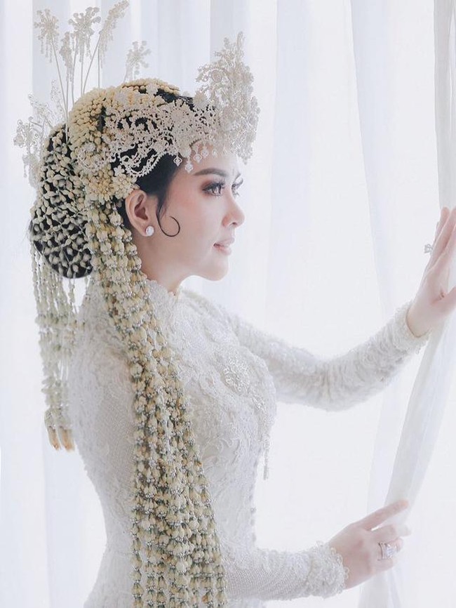 Syahrini menikah dengan Reino Barack di Masjid Camii, Tokyo, Jepang. Walaupun menikah di luar negeri, namun Syahrini tetap memilih mengenakan baju kebaya pengantin Sunda. Dengan kebaya putih yang dipenuhi bordiran bunga dan siger di kepalanya, penampilan Syahrini terlihat anggun dan menawan. Foto: Instagram