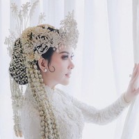 Syahrini menikah dengan Reino Barack di Masjid Camii, Tokyo, Jepang. Walaupun menikah di luar negeri, namun Syahrini tetap memilih mengenakan baju kebaya pengantin Sunda. Dengan kebaya putih yang dipenuhi bordiran bunga dan siger di kepalanya, penampilan Syahrini terlihat anggun dan menawan. Foto: Instagram