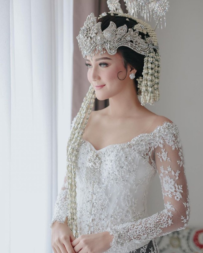Selanjutnya ada Erica Putri yang juga memilih melangsungkan pernikahan dengan menggunakan adat Sunda. Kakak dari Citra Kirana itu terlihat cantik dan mempesona dalam balutan kebaya pengantin Sunda. Menggunakan softlens berwarna terang yang dipadukan dengan riasan wajah yang flawless membuat penampilan Erica Putri bak seorang putri. Foto: Instagram