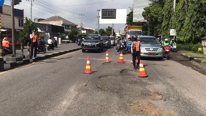 Petugas memasang traffic cone di jalan rusak di Kleco, Senin (24/1/2022).