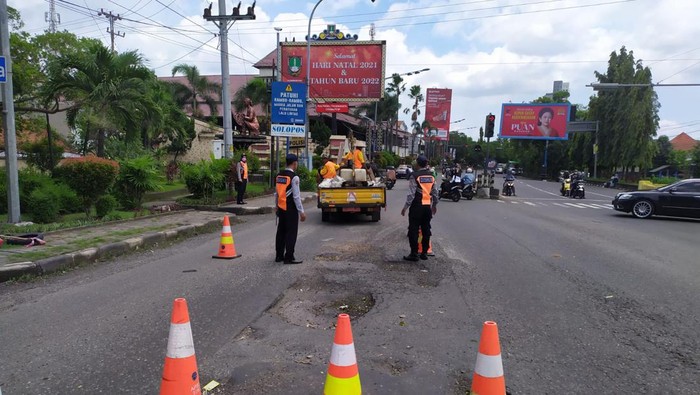 Petugas memperbaiki lubang di Jalan Slamet Riyadi, Kleco, Solo, Senin (24/1/2022).