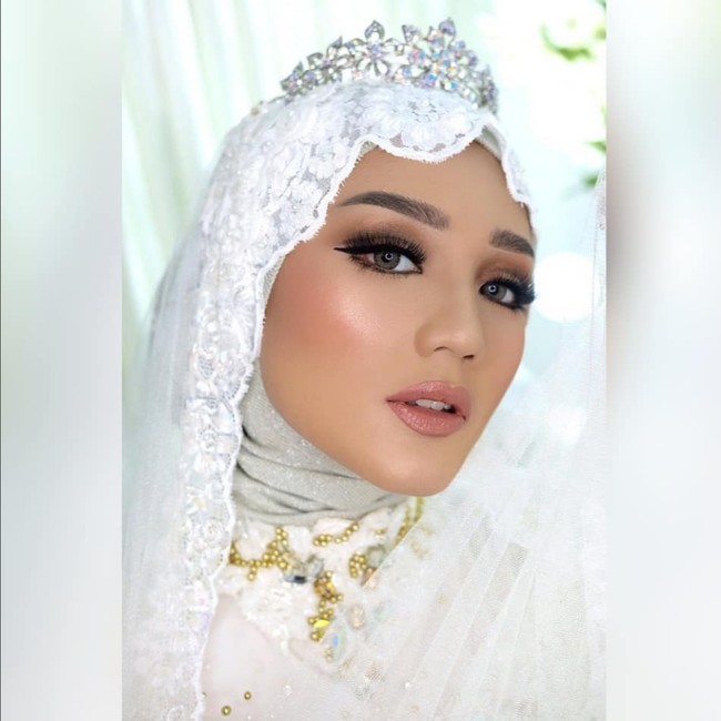 Tampilan makeup no makeup oleh MUA @tiarasariweddingmakeup bisa juga menjadi inspirasi rias pengantin hijab modern. Detail eyeliner yang simpel dan veil wedding dari bahan brocade membuat kamu terlihat anggun. Foto: Dok. Instagram @tiarasariweddingmakeup.