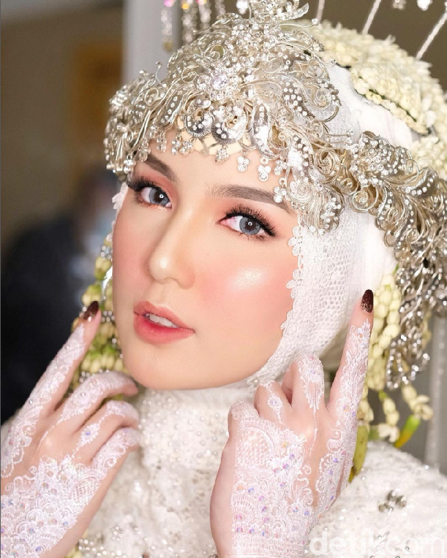 Inspirasi rias pengantin hijab terakhir adalah Thai Look dari MUA @ikawatifitria. Pengantin berhijab terlihat flawless dengan tema Thai Look ditambah dengan ombre lipstick pink membuat pengantin semakin pangling. Foto: Dok. Instagram @ikawatifitria.