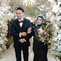 Untuk resepsi pernikahan, Achmad Megantara dan Asri Faradila memilih tema internasional. Keduanya tampil kompak mengenakan busana berwarna biru tua. Senyum sumringah pun tampak terpancar dari wajah pengantin baru ini. Foto: Instagram