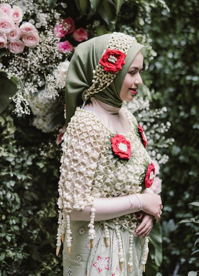 Setelah melangsungkan lamaran, keduanya pun menjalani proses siraman. Dengan mengenakan hijab dan kain berwarna hijau, penampilan Asri Faradila terlihat cantik. Penampilannya itu semakin dipermanis dengan hiasan bunga mawar merah di kepala dan baju siramannya. Foto: Instagram