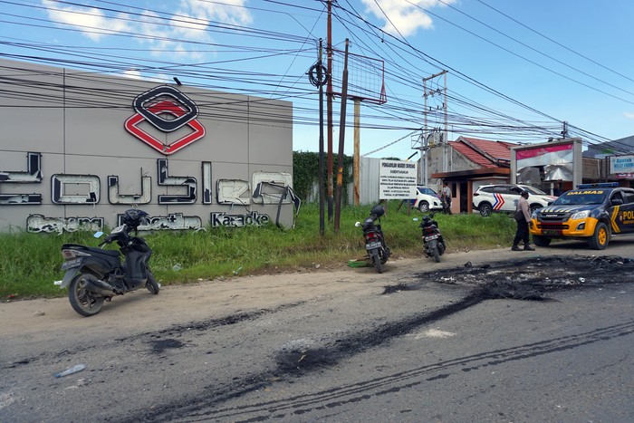 Sejumlah polisi berjaga di tempat hiburan malam Double O mengungsi usai bentrokan di Kota Sorong, Papua Barat, Selasa dini hari (25/1/2022). Bentrok antara dua kelompok masyarakat itu mengakibatkan tempat hiburan malam Double O dibakar massa, sebanyak 18 orang tewas serta 31 pekerja mengungsi. ANTARA FOTO/Olha Mulalinda/rwa.