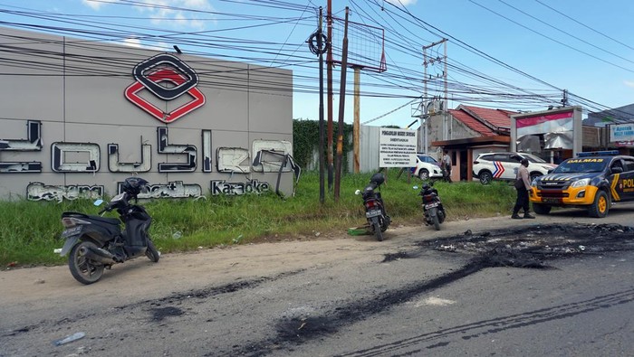 Sejumlah polisi berjaga di tempat hiburan malam Double O mengungsi usai bentrokan di Kota Sorong, Papua Barat, Selasa dini hari (25/1/2022). Bentrok antara dua kelompok masyarakat itu mengakibatkan tempat hiburan malam Double O dibakar massa, sebanyak 18 orang tewas serta 31 pekerja mengungsi. ANTARA FOTO/Olha Mulalinda/rwa.