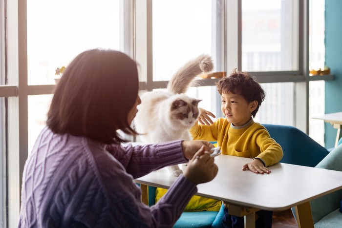 Ilustrasi ibu dan anak bermain dengan kucing