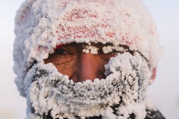 A runner looks at a photographer after taking part in the International Worlds coldest marathon at minus 53 degrees (-63.4 Fahrenheit) near Oymyakon, the republic of Sakha, also known as Yakutia, Russian Far East, Saturday, Jan. 22, 2022. Sixty five runners, including sportsmen from the United Arab Emirates, United States and Belarus, started the run at extremely low temperature in Oymyakon, Yakutias Pole of Cold. The international team of men and women ran full distance and half-marathon. (AP Photo/Ivan Nikiforov)