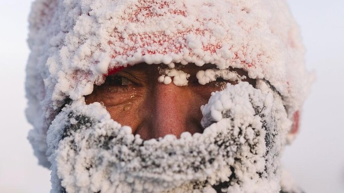 A runner looks at a photographer after taking part in the International World's coldest marathon at minus 53 degrees (-63.4 Fahrenheit) near Oymyakon, the republic of Sakha, also known as Yakutia, Russian Far East, Saturday, Jan. 22, 2022. Sixty five runners, including sportsmen from the United Arab Emirates, United States and Belarus, started the run at extremely low temperature in Oymyakon, Yakutia's Pole of Cold. The international team of men and women ran full distance and half-marathon. (AP Photo/Ivan Nikiforov)