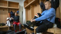 Anggota klub hoki 1979 mengenakan perlengkapan mereka di ruang ganti sebelum pertandingan di arena hoki di Beijing.