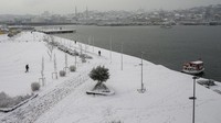 Orang-orang berjalan di atas salju di atas Tanduk Emas di Istanbul, Senin (24/1/2022). Menurut prakiraan cuaca, suhu di Istanbul pada kisaran 4 derajat Celcius. (AP/Emrah Gurel)