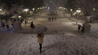 Orang-orang berjalan di alun-alun Syntagma yang tertutup salju selama badai salju di Athena, Yunani, Senin, (24/1/2022). Hujan salju lebat telah mengganggu lalu lintas udara di ibu kota Yunani Athena dan di kota tetangga terbesar di Turki, Istanbul, sementara beberapa pulau Aegea dan sebagian besar wilayah Turki diselimuti salju. (AP/Thanassis Stavrakis)