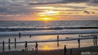 Warga menikmati suasana matahari tenggelam di Pantai Seminyak, Bali, (17/12/2021). (Ari Saputra/detikcom)