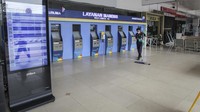Petugas berjalan di depan pintu keberangkatan di Bandara Halim Perdanakusuma, Jakarta.