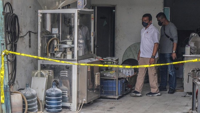 Petugas Kepolisian membawa barang bukti obat keras ilegal hasil produksi rumahan di Ruko kawasan Cikaret, Cibinong, Kabupaten Bogor, Jawa Barat, Rabu (26/1/2022). Dirtpid IV Bareskrim Polri bekerja sama dengan Ditres Narkoba Polda Jabar dan Sat Narkoba Polres Bogor berhasil mengungkap industri rumahan (home industri) obat keras golongan G ilegal yang merupakan jaringan Jabodetabek, serta mengamankan tiga orang tersangka inisial IW, WD dan YN. ANTARA FOTO/Yulius Satria Wijaya/aww.