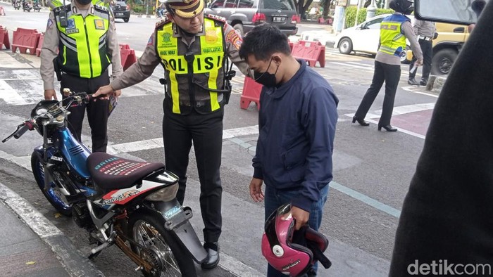 Polisi saat memberhentikan pengendara berknalpot bising di Bandung.