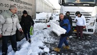 Seorang pengemudi truk terjebak selama berjam-jam di jalan tol sekop salju di Athena. (AP/Michael Varaklas)