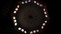 Sinar matahari menyinari jendela kaca patri gereja Espiritu Santo di komunitas Adat Puerpecha Comachuen. Banyak hal di Comachuen, gereja, cincin banteng, sumbangan amal, dibayar oleh para migran dengan uang yang mereka hasilkan dengan bekerja di Amerika Serikat.