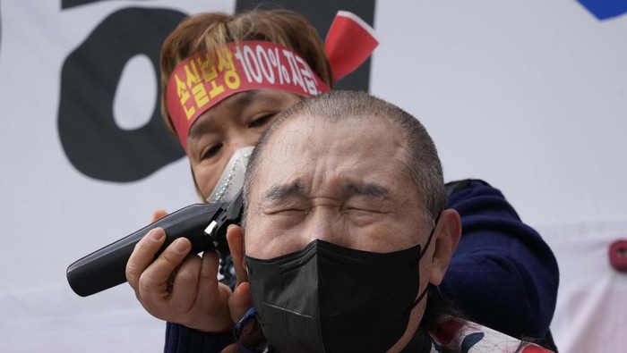 Protes Pembatasan, Pelaku UMKM Korsel Gunduli Kepala Small business owners have their heads shaved during a rally against the government's social distancing rules near the National Assembly in Seoul, South Korea, Tuesday, Jan. 25, 2022. South Korea recorded more than 8,000 new coronavirus infections for the first time Tuesday as health authorities reshape the country's pandemic response to address a surge driven by the highly contagious omicron variant. (AP Photo/Ahn Young-joon)
