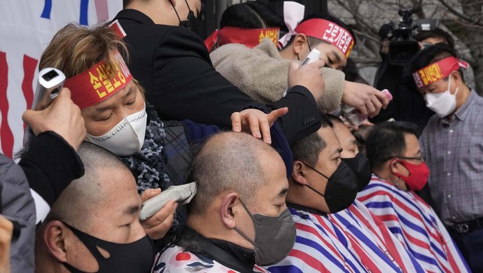 Protes Pembatasan, Pelaku UMKM Korsel Gunduli Kepala Small business owners have their heads shaved during a rally against the government's social distancing rules near the National Assembly in Seoul, South Korea, Tuesday, Jan. 25, 2022. South Korea recorded more than 8,000 new coronavirus infections for the first time Tuesday as health authorities reshape the country's pandemic response to address a surge driven by the highly contagious omicron variant. (AP Photo/Ahn Young-joon)