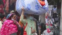 Pedagang kain menggotong dagangannya di kepala, di Pasar Jammu, India (21/1/2022). Kota Jammu, wilayah di utara India, mempunyai luas 240 km persegi atau sepertiga Jakarta. (AP Photo/Channi Anand)