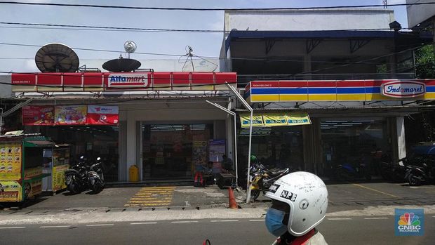 Sejumlah warga melewati toko Indomaret dan Alfamart yang berlokasi di Sukabumi Utara, Jakarta Barat, Kamis (27/1/2022). Indomaret dan Alfamart mungkin terlihat selalu berdekatan yang memiliki banyak persamaan. Namun, keduanya mengakui bahwa mereka memiliki keunggulannya masing-masing. Ada yang mengusung keunggulan dari segi harga lebih murah, kapasitas toko lebih luas, pelayanan lebih ramah atau kenyamanan suasana. Pantauan dilokasi Indomaret dan Alfamart berdekatan dan bersampingan berlada di berbagai lokasi contohnya, Petukangan Utara, Kreo, Duri Kosambi dan Kebon Jeruk. (CNBC Indonesia/Tri Susilo)