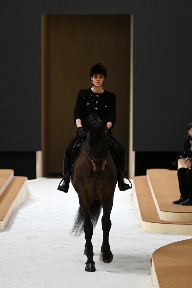 Bergaya ala equestrian, Putri Charlotte yang juga dikenal sebagai atlet berkuda muncul dalam balutan busana serba hitam. Ia mengenakan blouse berpotongan jaket tweed khas Chanel yang berhiaskan payetan mengilap. (Foto: Getty Images/Pascal Le Segretain)