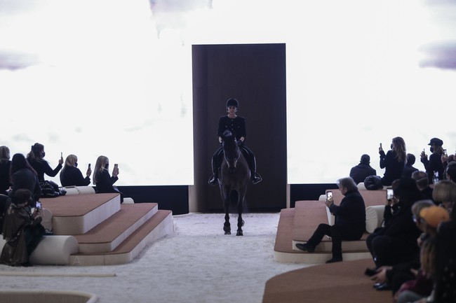Chanel menggelar fashion show adibusana (haute-couture) musim semi-panas 2022 di Paris Fashion Week, Selasa (25/1/2022). Sebagai pembuka koleksi karya desainer Virginie Viard itu, tampil Putri Monako Charlotte Casiraghi berkuda menelusuri catwalk. (Foto: AP/Lewis Joly)