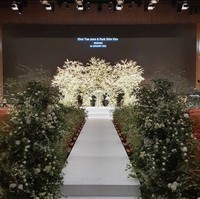 Bagian selasar di mana pengantin wanita berjalan menuju altar pun dihiasi bunga putih dan rangkaian tanaman hijau. Foto: Instagram/@grove008, Soulpage Photography