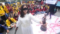 Tampak mahasiswi mata tertutup sembari memegang patung dewi Yunani sebagai lambang keadilan.