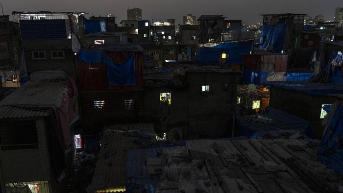 Fire brigade personnel along with others clear debris after a 5-story building collapsed at a slum in Mumbai, India, Wednesday, Jan. 26, 2022. (AP Photo/Rafiq Maqbool)