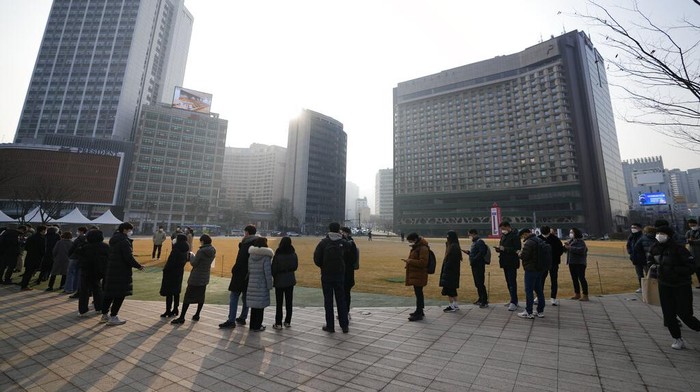 People queue in line for the coronavirus test while maintaining social distancing at a temporary screening clinic for the coronavirus near the Seoul City Hall in Seoul, South Korea, Wednesday, Jan. 26, 2022. (AP Photo/Lee Jin-man)