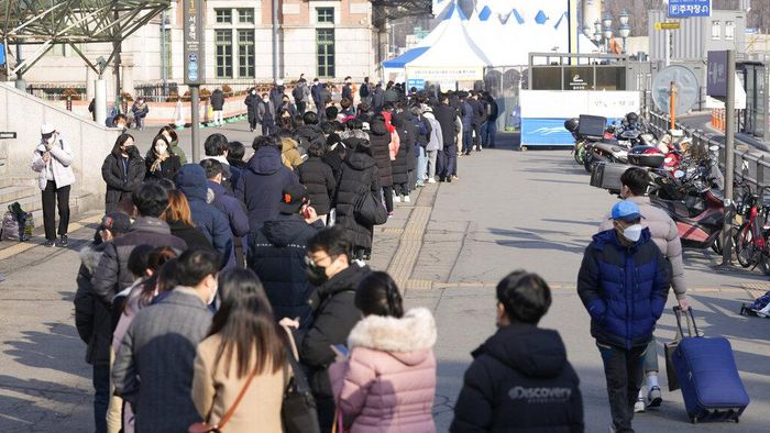 People queue in line for the coronavirus test while maintaining social distancing at a temporary screening clinic for the coronavirus near the Seoul City Hall in Seoul, South Korea, Wednesday, Jan. 26, 2022. (AP Photo/Lee Jin-man)
