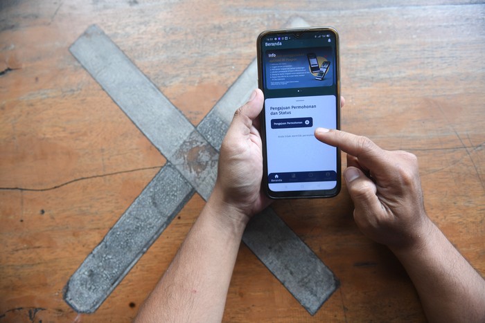 Warga mengakses aplikasi M-Paspor di Jakarta, Kamis (27/1/2022). Kemenkumham resmi meluncurkan aplikasi Mobile Paspor atau M-Paspor yang dapat digunakan masyarakat untuk membuat paspor secara daring. ANTARA FOTO/Akbar Nugroho Gumay/hp.