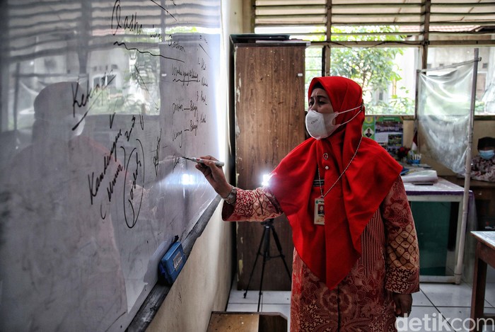 Sejumlah siswa-siswi mengikuti pembelajaran tatap muka 100 persen di kawasan SDN Rorotan 02 Pagi, Rorotan, Jakarta Utara, Kamis (27/1). Pembelajaran tatap muka ini berlangsung di tengah melonjaknya kasus Omicron.
