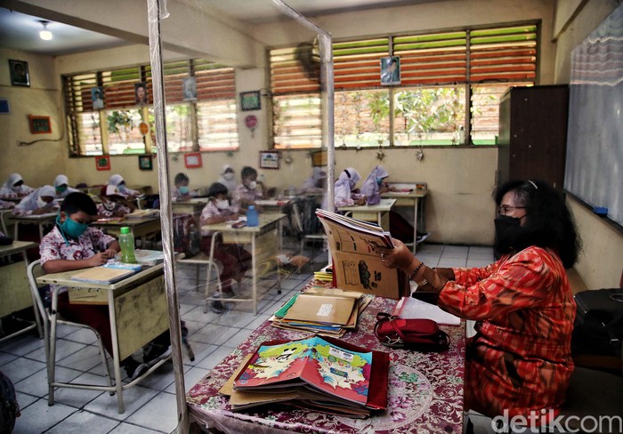 Sejumlah siswa-siswi mengikuti pembelajaran tatap muka 100 persen di kawasan SDN Rorotan 02 Pagi, Rorotan, Jakarta Utara, Kamis (27/1). Pembelajaran tatap muka ini berlangsung di tengah melonjaknya kasus Omicron.