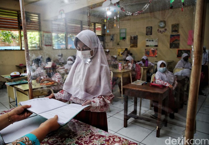 Sejumlah siswa-siswi mengikuti pembelajaran tatap muka 100 persen di kawasan SDN Rorotan 02 Pagi, Rorotan, Jakarta Utara, Kamis (27/1). Pembelajaran tatap muka ini berlangsung di tengah melonjaknya kasus Omicron.