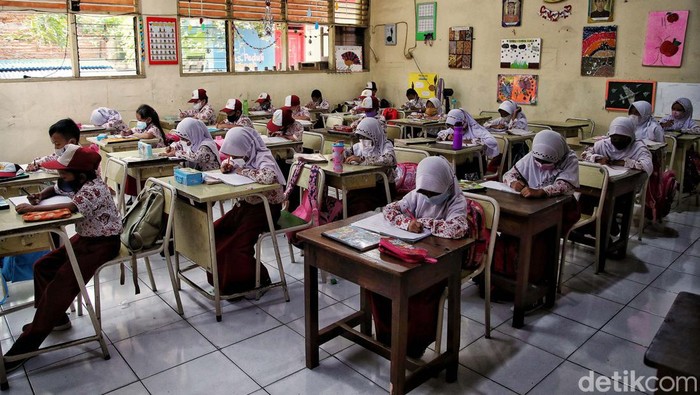 Sejumlah siswa-siswi mengikuti pembelajaran tatap muka 100 persen di kawasan SDN Rorotan 02 Pagi, Rorotan, Jakarta Utara, Kamis (27/1). Pembelajaran tatap muka ini berlangsung di tengah melonjaknya kasus Omicron.