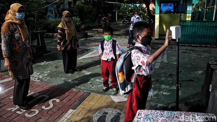 Sejumlah siswa-siswi mengikuti pembelajaran tatap muka 100 persen di kawasan SDN Rorotan 02 Pagi, Rorotan, Jakarta Utara, Kamis (27/1). Pembelajaran tatap muka ini berlangsung di tengah melonjaknya kasus Omicron.