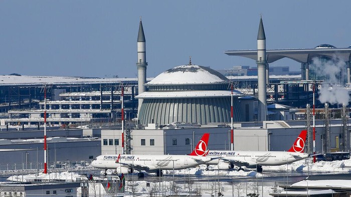 Potret Bandara Istanbul Tertutup Salju Tebal Planes are parked at snow-covered Istanbul international airport in Istanbul, Turkey, Wednesday, Jan. 26, 2022. Rescue crews in Istanbul and Athens dug through snow and ice Tuesday to clear paralyzed roads and rescue people stranded overnight in their cars after snowstorms and a massive cold front brought much of Turkey and Greece to a standstill. (AP Photo/Emrah Gurel)